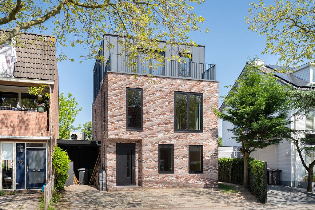 Modern brick house with large windows and trees.
