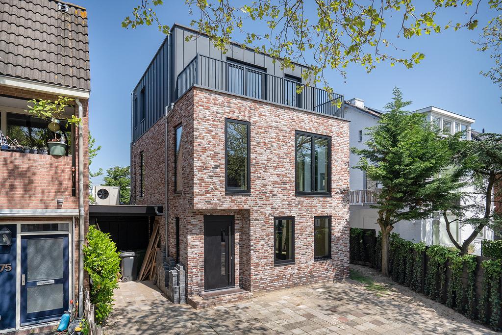 Modern brick house with large windows and trees.