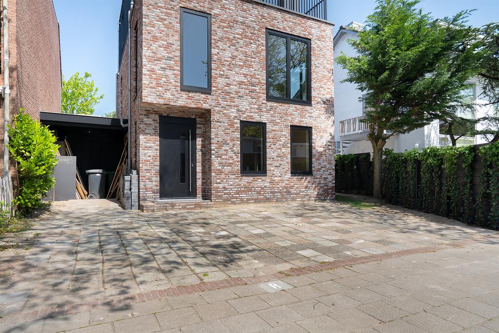 Modern brick house with large windows and driveway.