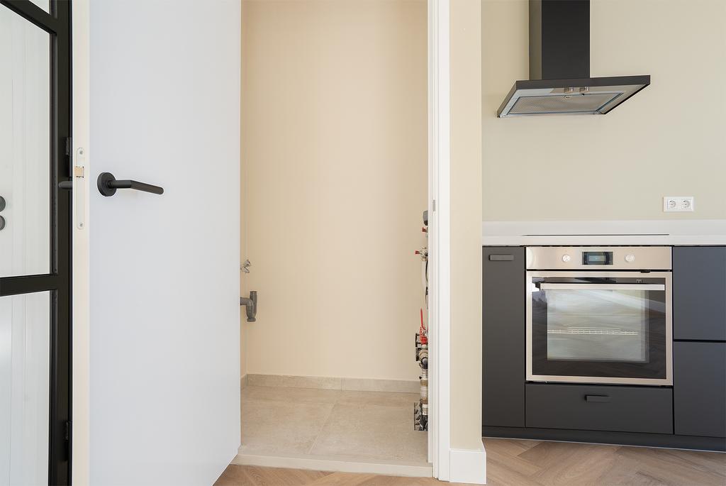 Modern kitchen with built-in oven and open door.