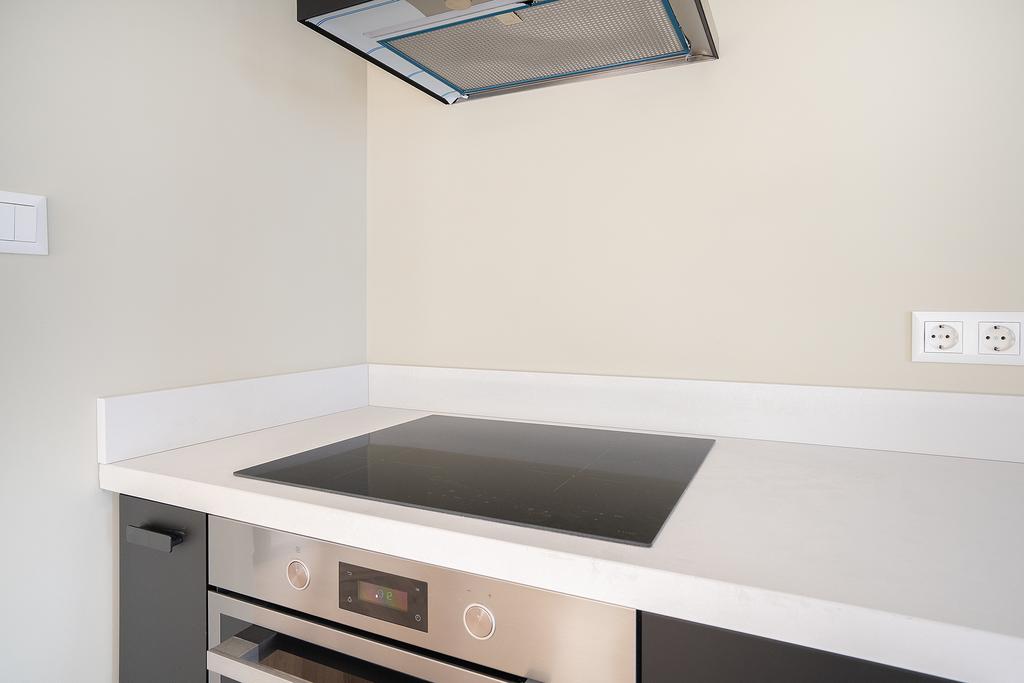 Modern kitchen with stovetop and oven.