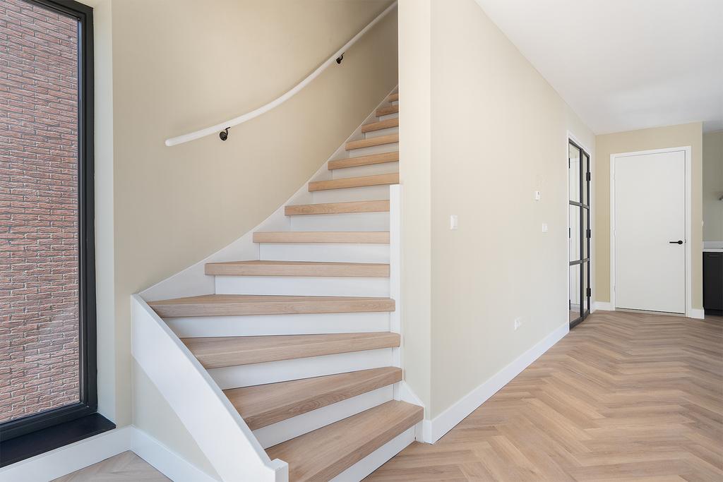 Modern wooden staircase with light walls
