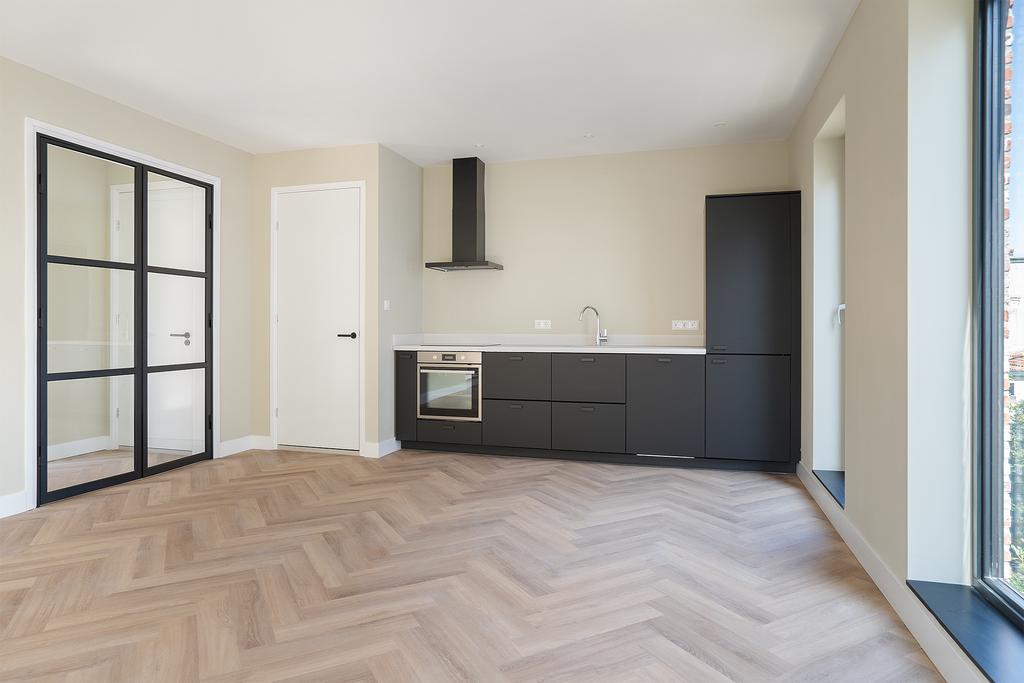 Modern kitchen with black cabinets and herringbone floor