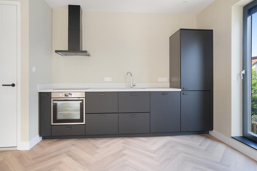 Modern kitchen with gray cabinets and wood floor