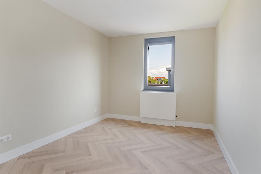 Empty room with window and wooden floor.