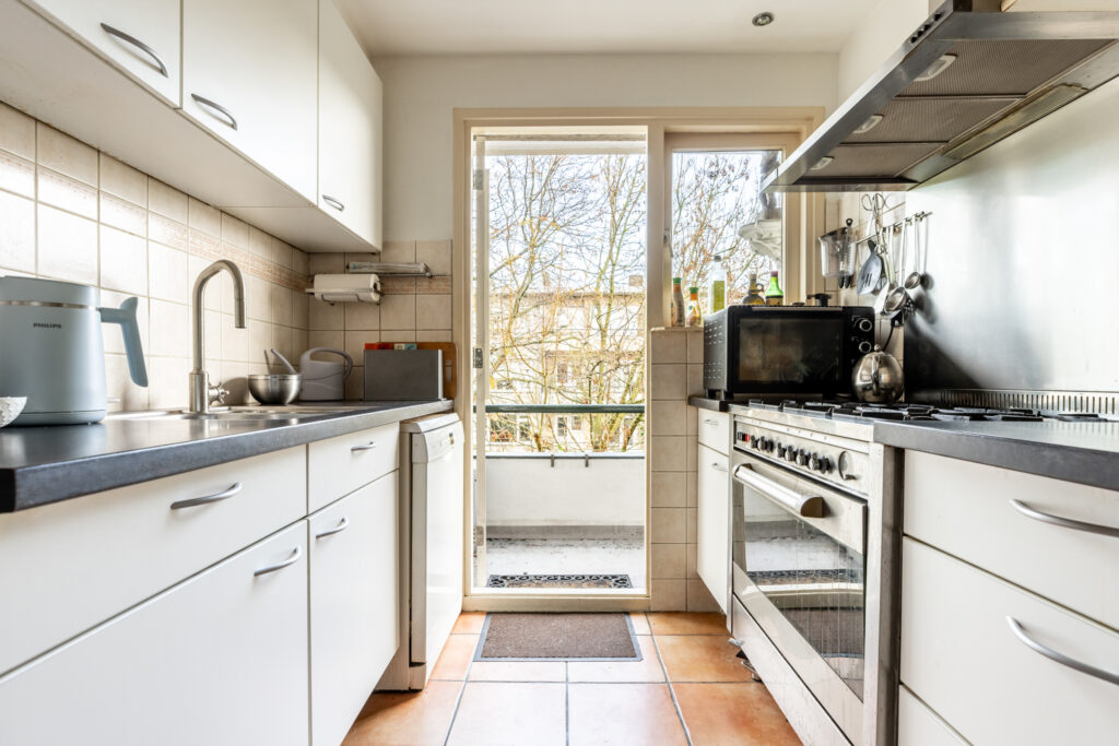 Modern kitchen with appliances and open door.