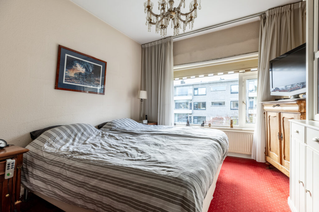 Cozy bedroom with double bed and window view.