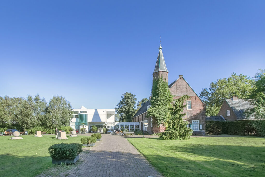 Historic church with adjacent modern building on sunny day.