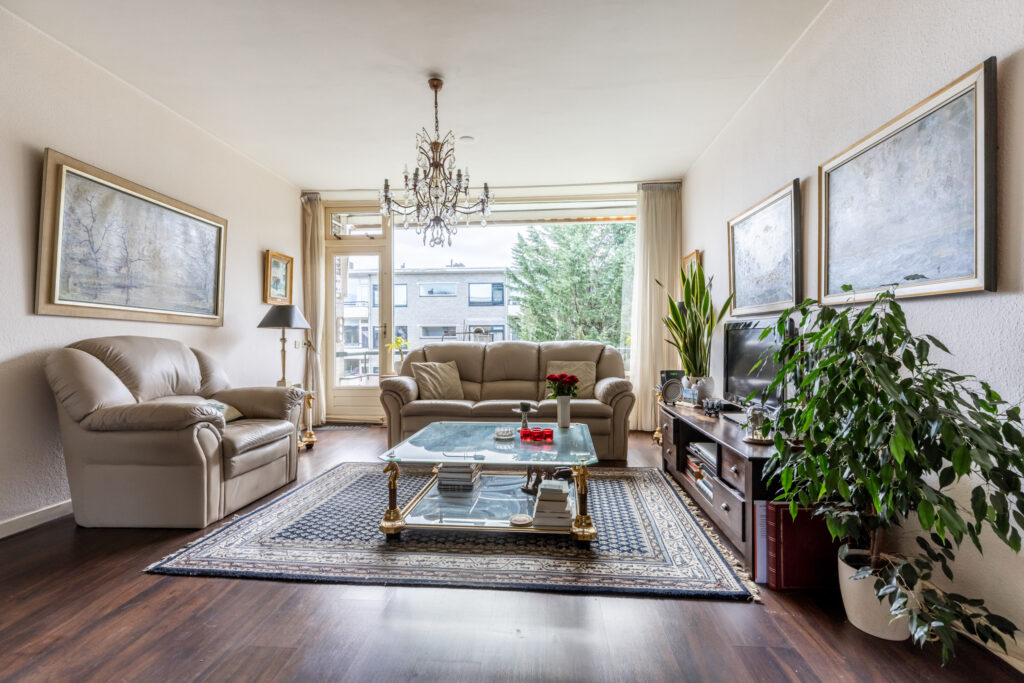 Cozy living room with chandelier and large window views.