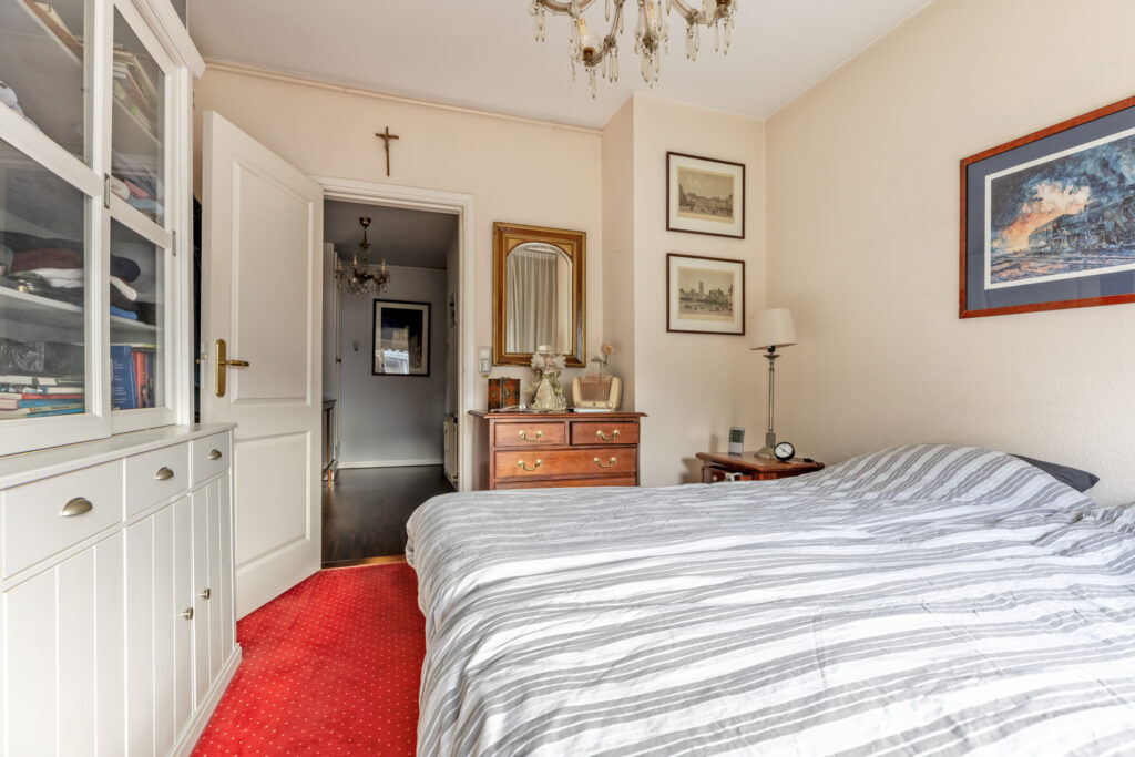 Cozy bedroom with striped bed and wooden furniture