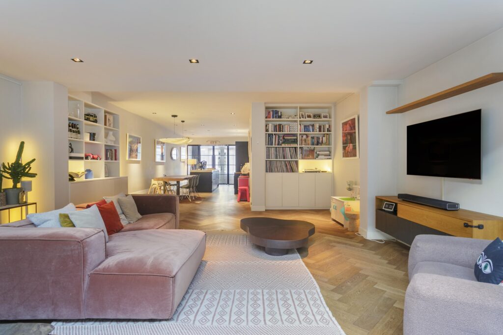 Modern open-plan living room with bookshelves.
