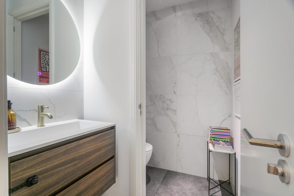 Modern bathroom with floating vanity and stack of books.