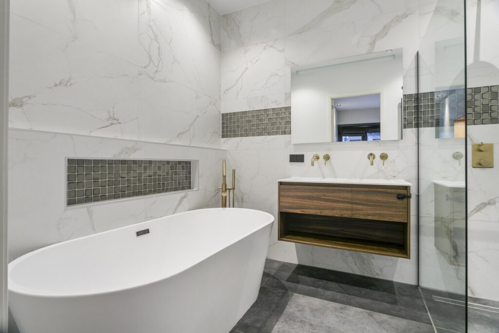 Modern bathroom with freestanding tub and marble walls.