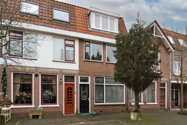 Dutch townhouse with red roof and large windows
