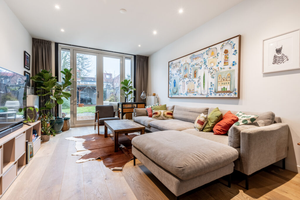 Cozy modern living room with large windows and plants.