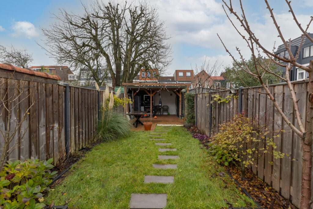 Backyard with grass path and wooden fence
