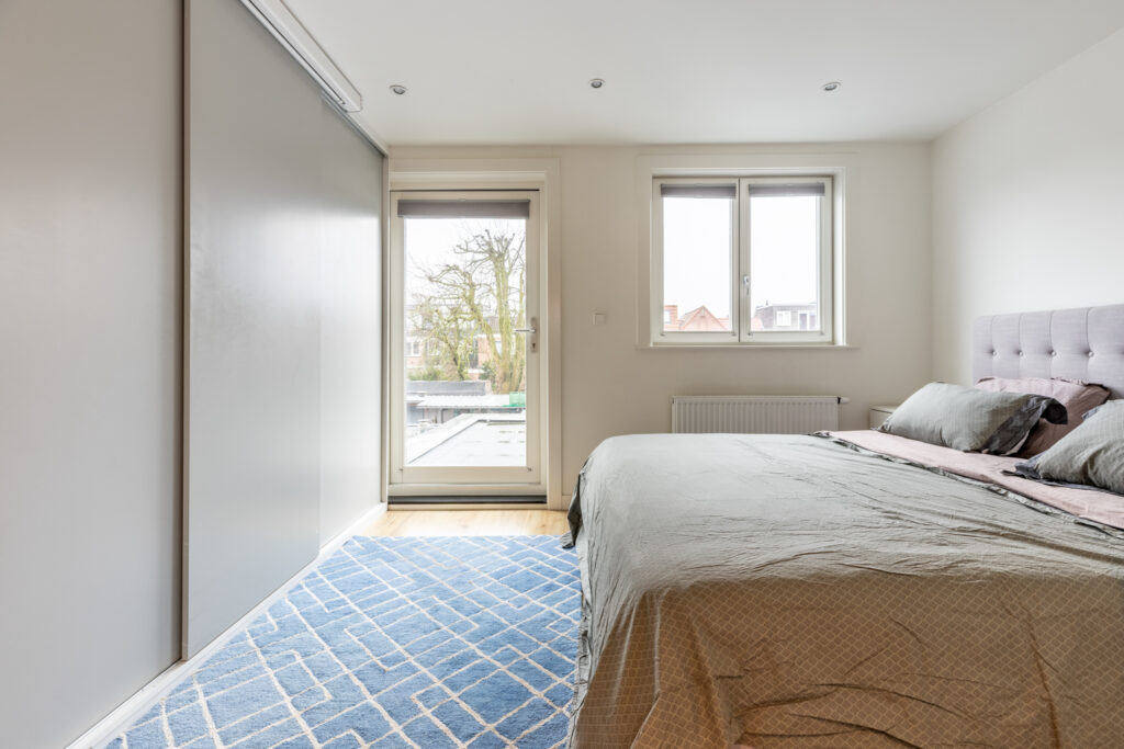 Modern bedroom with large window and bed