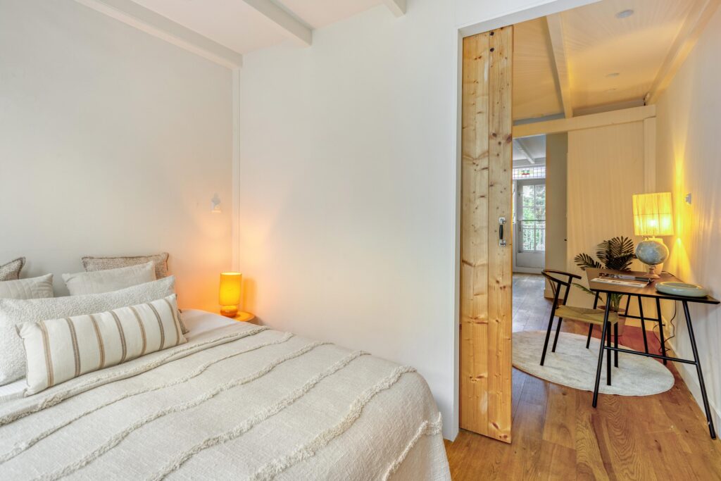 Cozy bedroom with natural light and desk area.