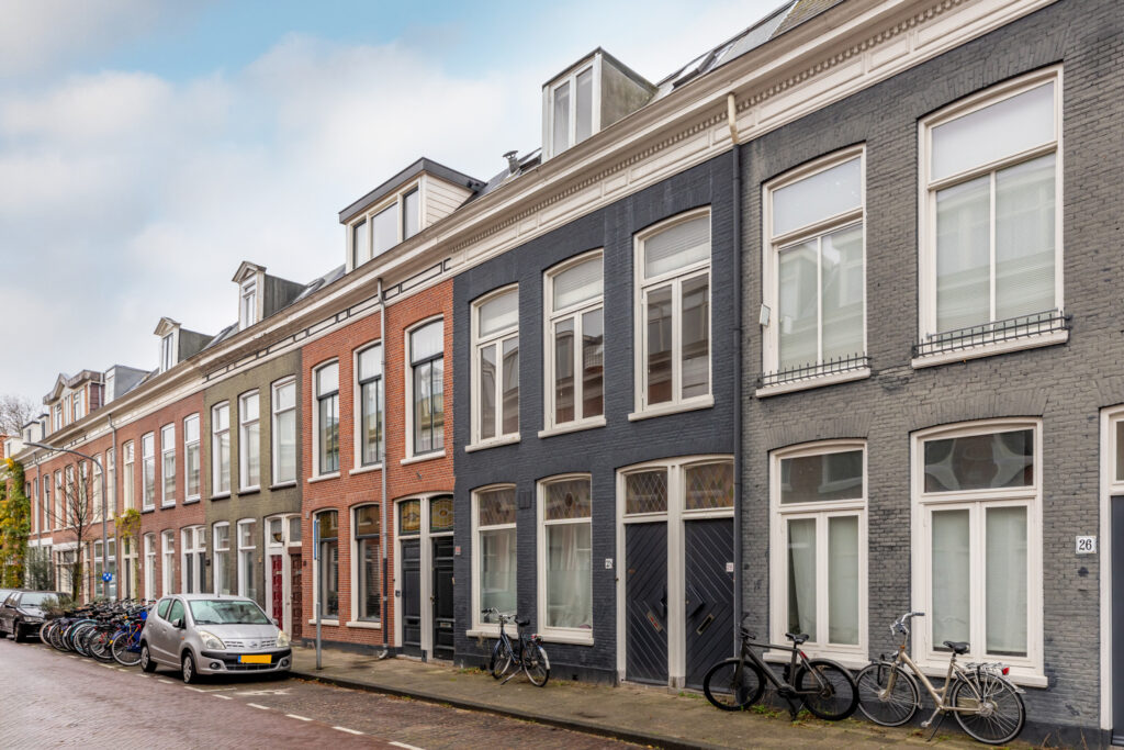 Row of bicycles parked outside European townhouses.
