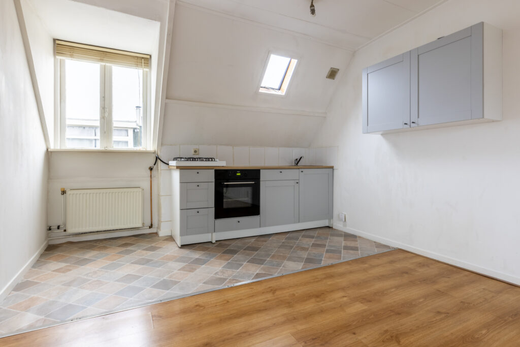 Bright attic kitchen with slanted roof and skylight.
