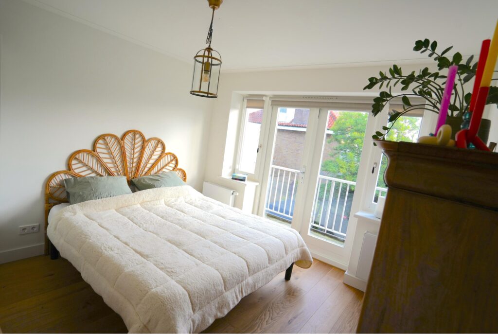 Cozy bedroom with rattan headboard and large window.