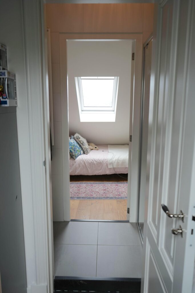 View into bedroom with sloped ceiling and skylight